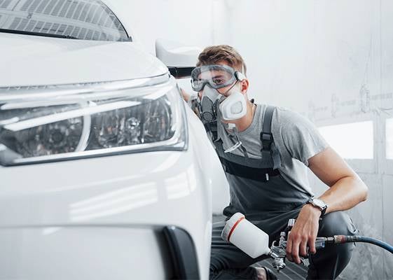 inspecting car while wearing respirator and goggles